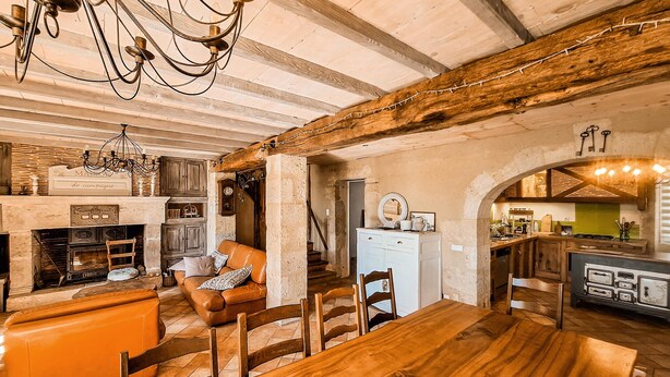 Ein rustikales Interieur mit einem Holztisch, einem Kamin und einer Küchenzeile.