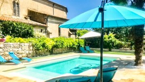 Ein Pool mit Liegestühlen und Sonnenschirm.