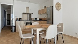 A modern kitchen with a dining area, wooden flooring, and white chairs. - Beautiful sea view apartment, hyper center Ajaccio (Ajaccio)