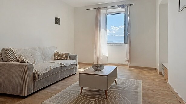 A modern living room with a sofa, a coffee table, and a large window with curtains. - Beautiful sea view apartment, hyper center Ajaccio (Ajaccio)