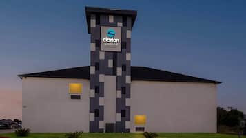 A modern hotel with a distinctive tower featuring a logo and the name 'Clarion Pointe' by Choice Hotel.
