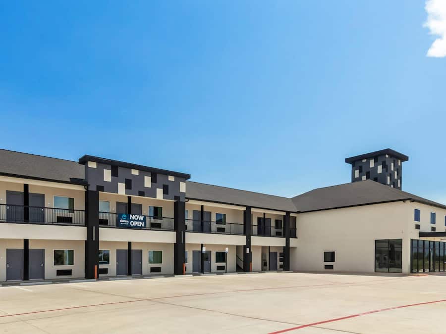 A modern hotel with a central courtyard, multiple balconies, and a prominent tower structure.