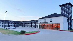 A modern hotel with a central courtyard, a glass entrance, and a parking area. - Clarion Pointe Port Lavaca (Port Lavaca)