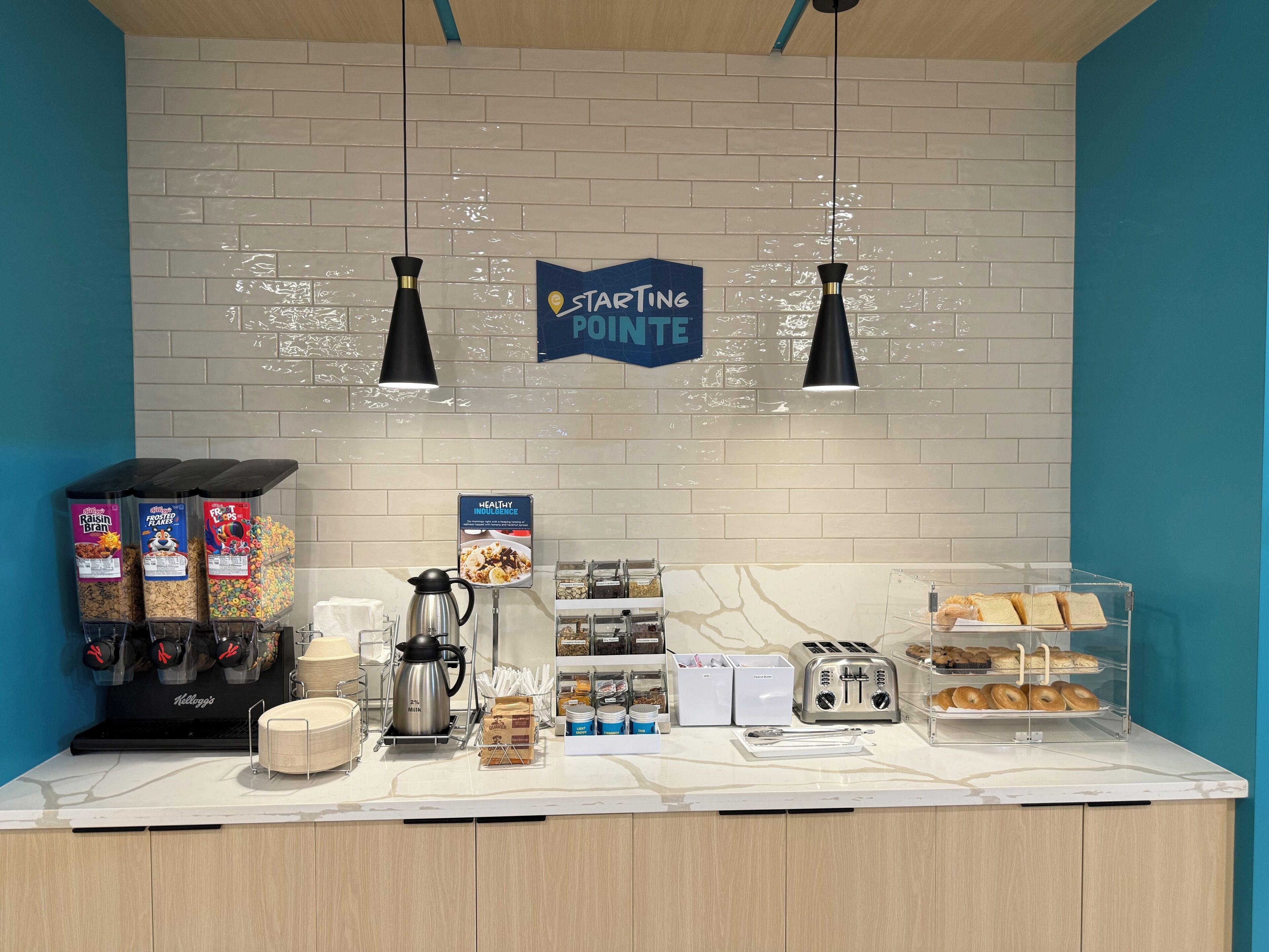 A breakfast bar with various food items, a coffee maker, and a toaster.