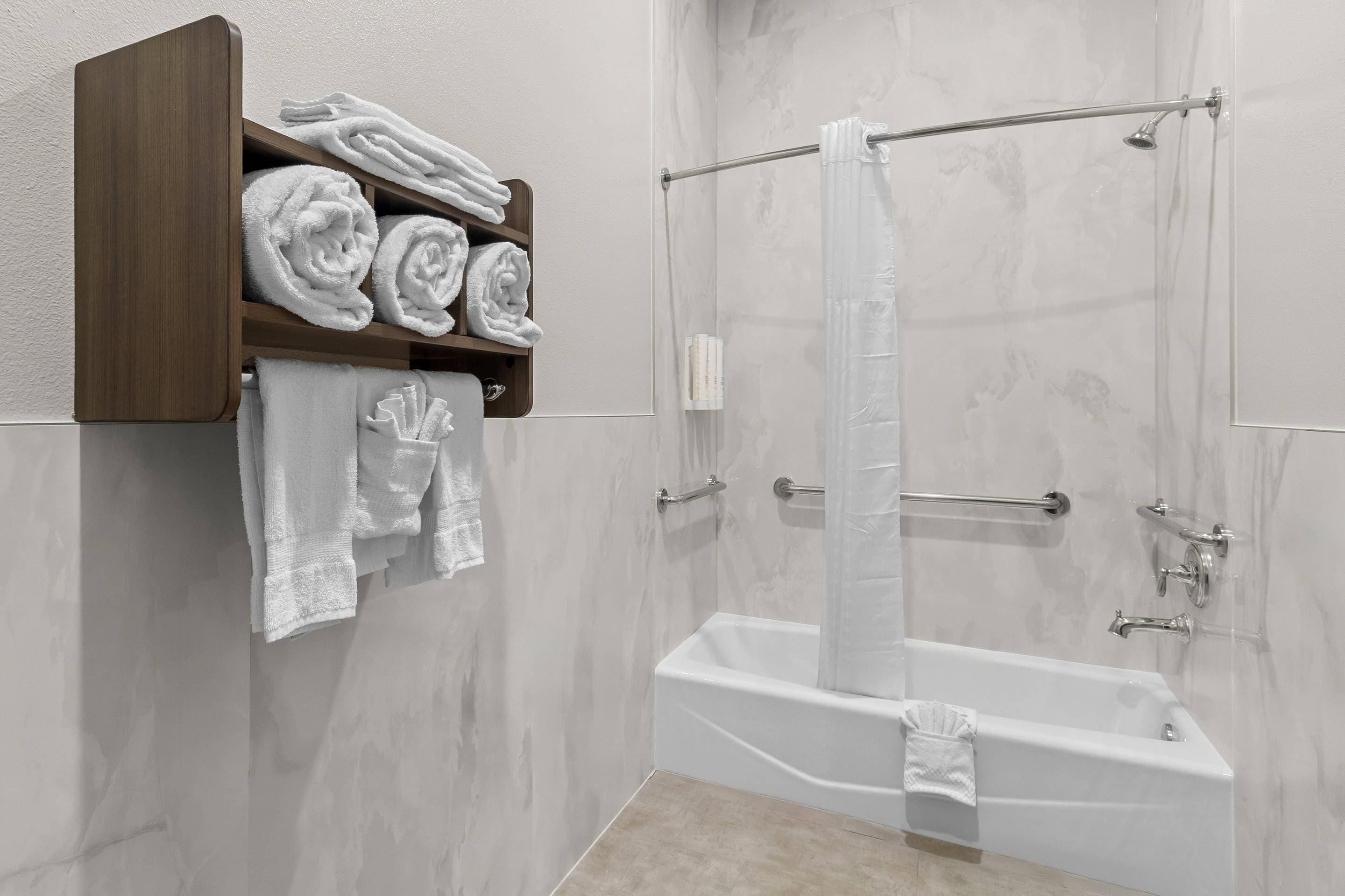 Une salle de bain moderne avec une douche à parois de verre, un porte-serviettes intégré et une baignoire.