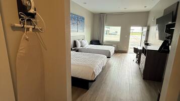 A hotel room with a bed, a desk, a chair, and a television.
