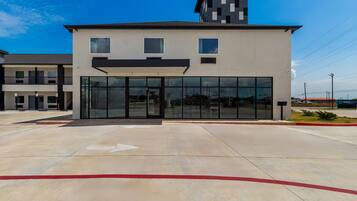 A modern building with a flat roof, large glass windows, and a red curb.