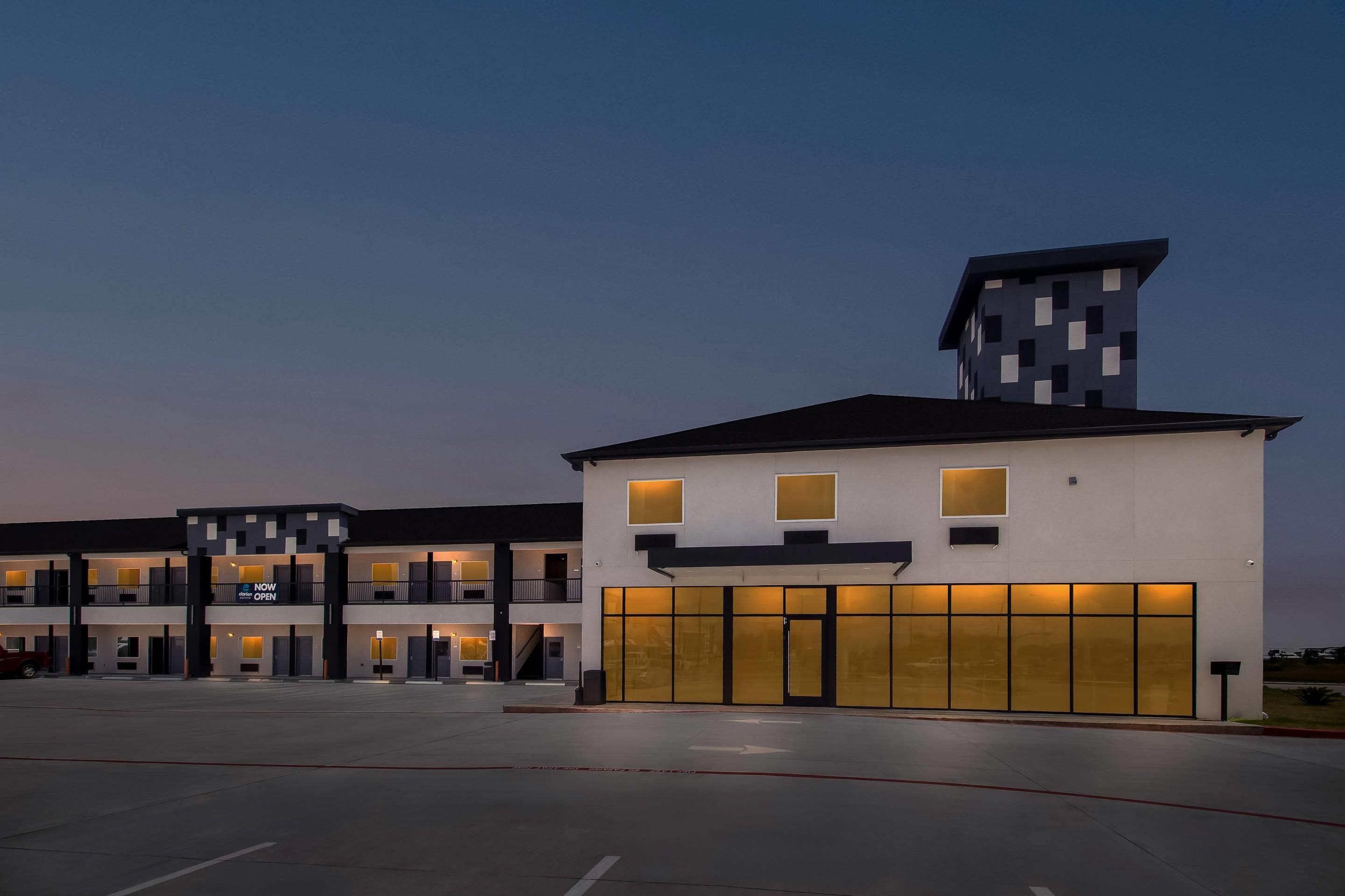 A modern building with a flat roof, multiple windows, and a sign indicating it's now open.