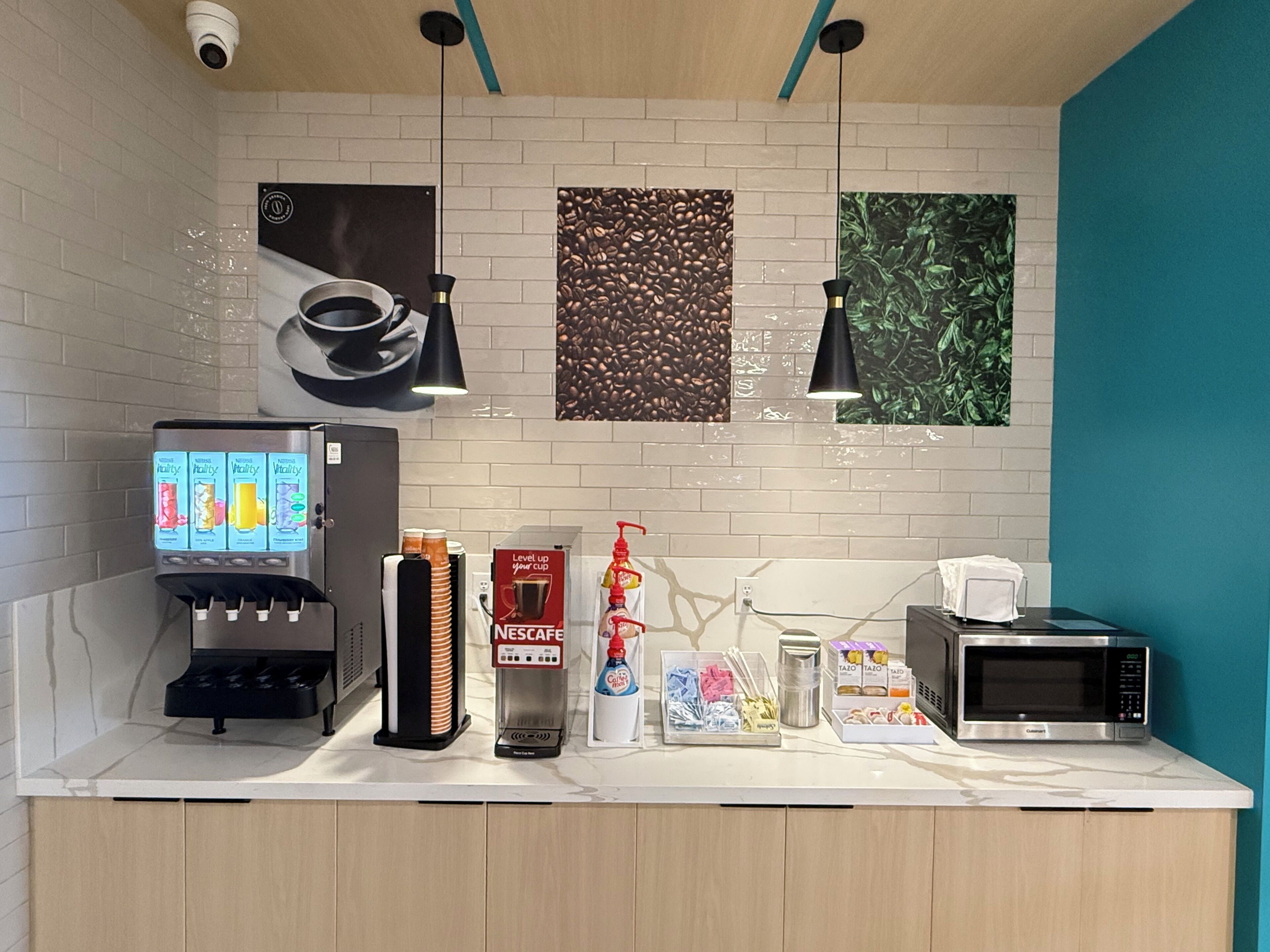 Een kitchenette met een koffiezetapparaat, een magnetron en een Nespresso-apparaat.