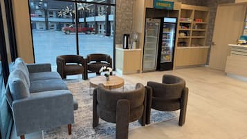 Een modern interieur met zitplaatsen, een koelkast en uitzicht op buiten.