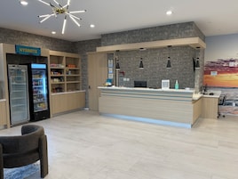 Zona de recepción con mostrador, estación de hidratación y área de estar.