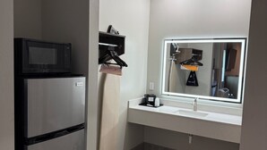 A compact bathroom with a built-in sink, a mirror, and a microwave. - Clarion Pointe Port Lavaca (Port Lavaca)