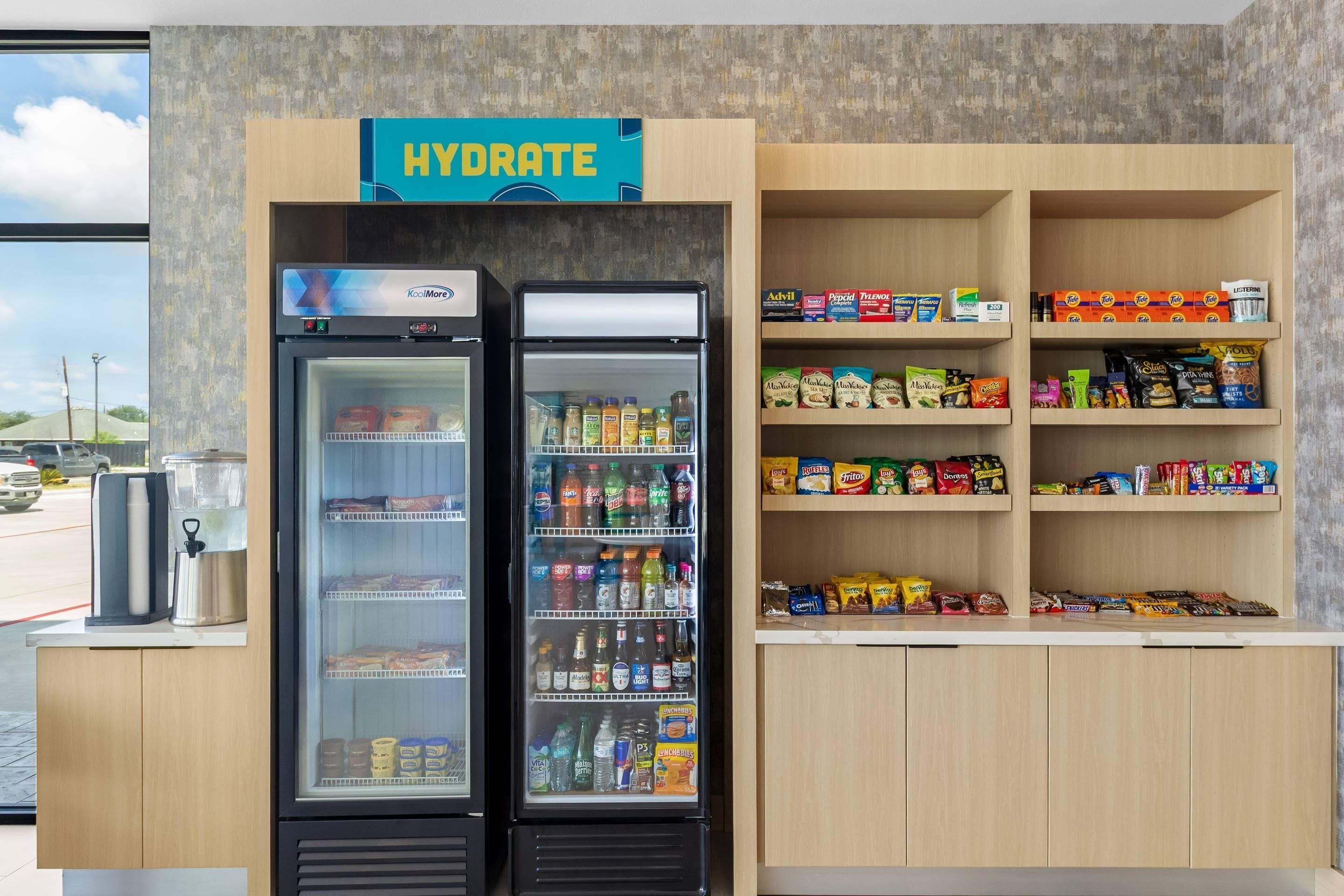 Un punto de hidratación con dos refrigeradores llenos de bebidas y aperitivos, como papas fritas y agua embotellada.