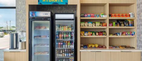 A hydration station with two refrigerators stocked with beverages and snacks, including chips and bottled water.