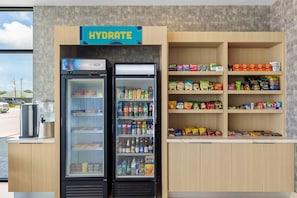 Un punto de hidratación con dos refrigeradores llenos de bebidas y aperitivos, como papas fritas y agua embotellada.