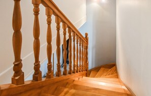 A wooden staircase with a handrail and a light fixture above it. - MAISON PROCHE DE LA MER 1 (Bricqueville sur mer)