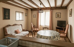 A cozy living room with a sofa, chairs, a round table, a television, and a window with curtains. - Cozy home in Barneville Carteret with WiFi (Barneville Carteret)