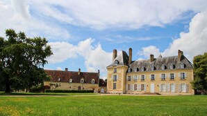 A large, historic building with multiple windows and a tower, surrounded by a well-maintained lawn. - Beautiful home in Aveze with house a panoramic view (Aveze)