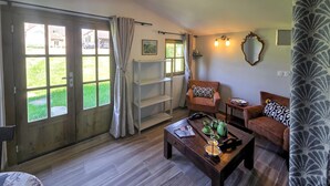 A room with a wooden floor, two sofas with patterned cushions, a coffee table with a teapot, a window with curtains, and a wall-mounted shelf with a vase. - Beautiful home in Aveze with house a panoramic view (Aveze)