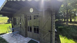 A rustic wooden building with a covered porch, a bench, and a door with glass panels. - Beautiful home in Aveze with house a panoramic view (Aveze)