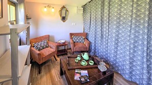 A cozy room with two armchairs, a wooden coffee table with a teapot and cups, and a patterned curtain. - Beautiful home in Aveze with house a panoramic view (Aveze)