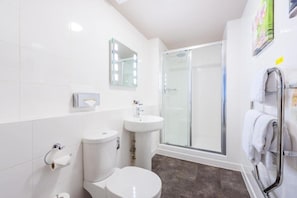 A modern bathroom with a toilet, sink, and shower. - Nottingham City Centre Hotel Twin Room (Nottingham)