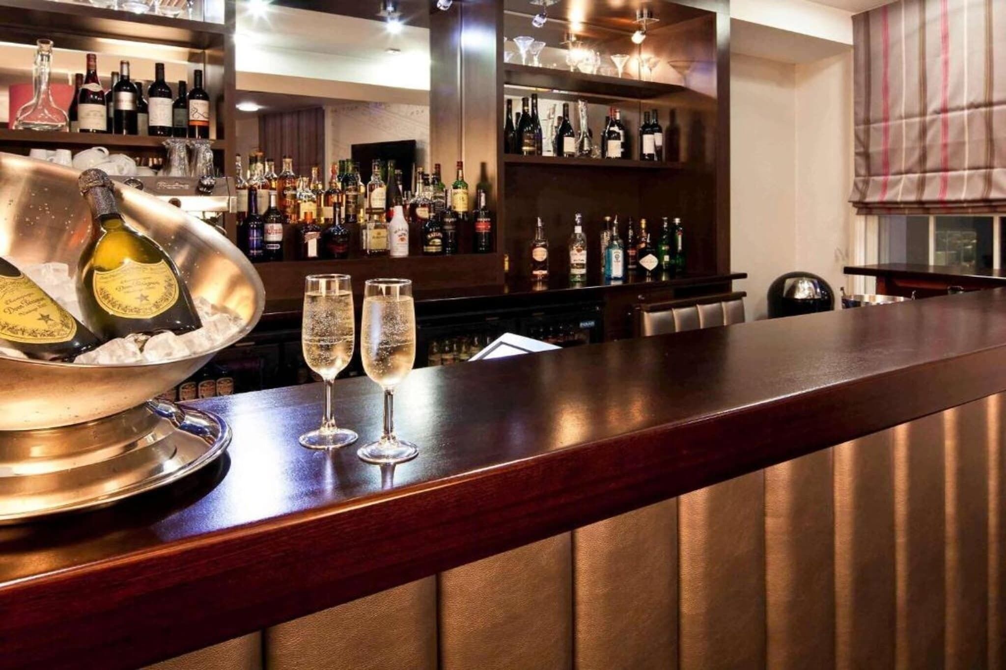 A bar area with bottles and glasses.