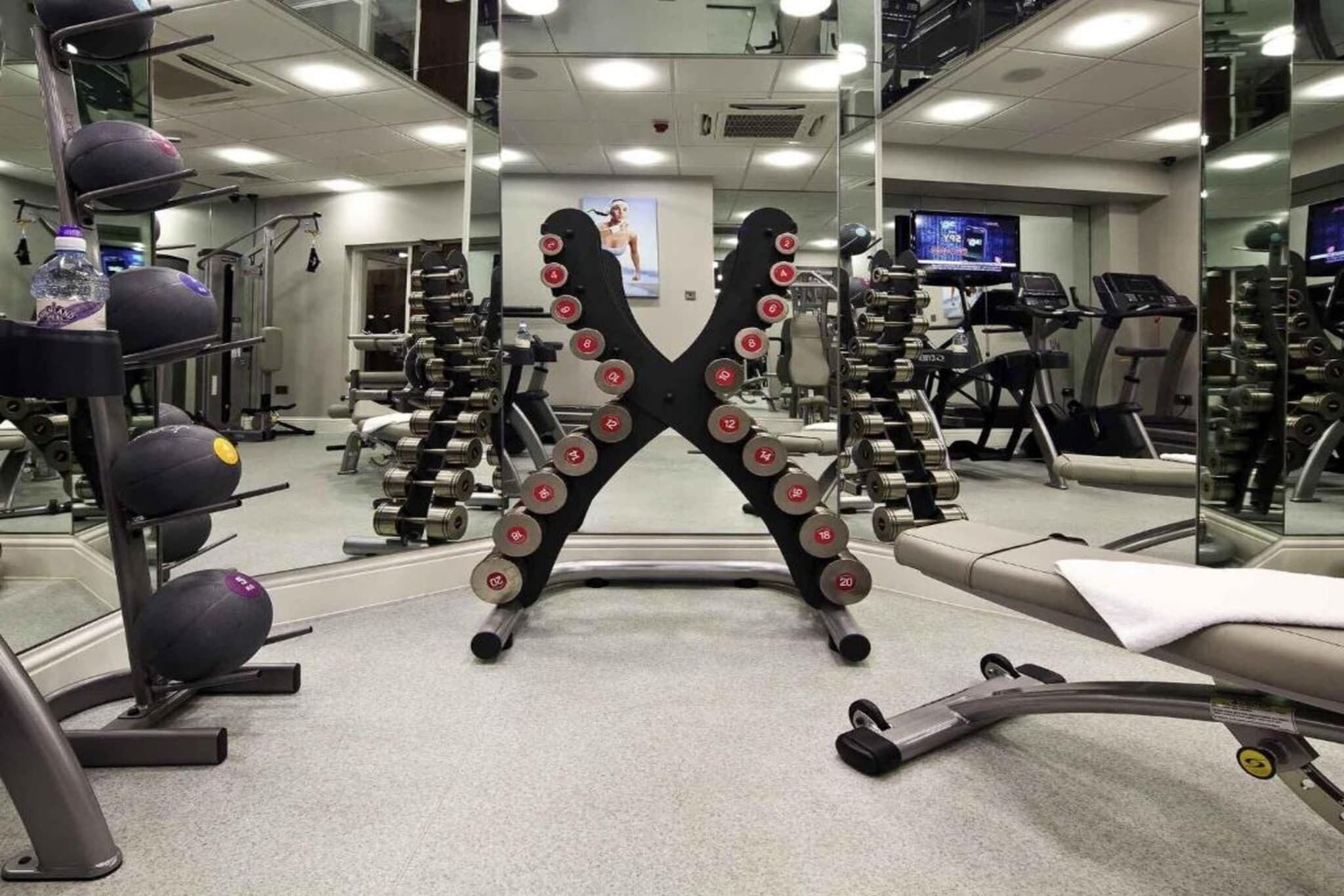A gym with weightlifting equipment, treadmills, and exercise machines.
