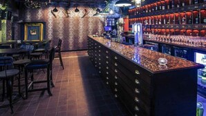 A bar area with a counter, stools, and shelves with bottles. - Nottingham City Centre Hotel Double Room (Nottingham)