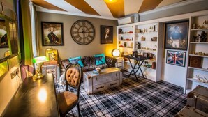 A room with a checkered floor, a sofa, a table, a clock, and shelves with various items. - Nottingham City Centre Hotel Double Room (Nottingham)