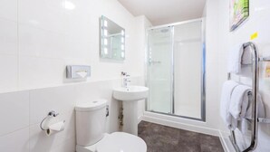 Ein modernes Badezimmer mit Toilette, Waschbecken und Dusche.