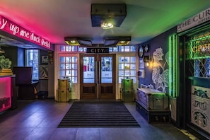 A hotel lobby with a neon sign, a city-themed door, and a Starbucks logo. - Nottingham City Centre Deluxe Quad Room (Nottingham)
