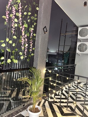 Ein modernes Interieur mit Glastrennwand, Topfpflanze und dekorativer Lichterkette.
