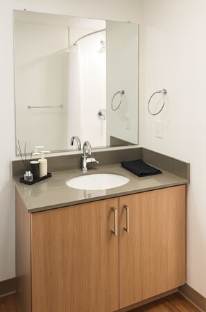 A bathroom with a large mirror, a sink, a towel rack, and a cabinet.