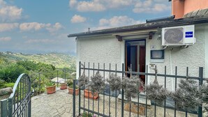 A house with a white exterior, a blue door, and a number '50' on the wall. - Stunning home in San Lorenzo della Cost with house a panoramic view (San Lorenzo della Cost)