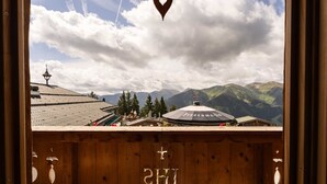 A wooden cabin with a view of mountains and a church steeple. - Panorama Alm Chalet - Jägersruh Zwei, Ski-in / out & mountain view (Saalbach)