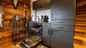 A kitchen with wooden walls, a mounted deer skull, and a dishwasher. - Panorama Alm Chalet - Jägersruh Zwei, Ski-in / out & mountain view (Saalbach)