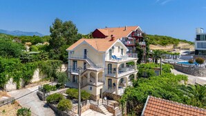 Un edificio a più piani con balconi, piscina e vista sul mare.