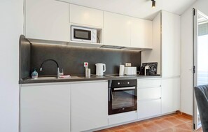A modern kitchen with a built-in microwave, a coffee machine, a toaster, and a pizza menu holder. - Stunning apartment in Kotor with WiFi (Kotor)