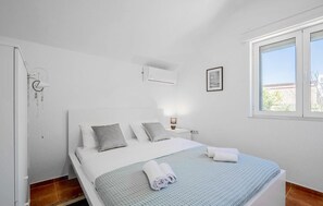 A bedroom with a bed, bedside lamp, air conditioning unit, window, and a framed picture on the wall. - Stunning apartment in Kotor with WiFi (Kotor)