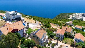 Un quartier résidentiel situé sur la côte, avec des maisons, une piscine et une vue sur la mer.