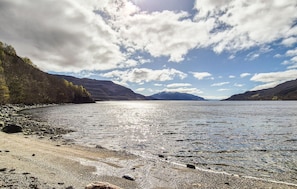 A lake with a rocky shoreline and mountains in the background. - 3 bedroom nice home in Sandeid (Sandeid)