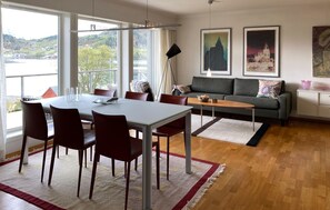 A dining area with a table and chairs, a sofa, and artwork on the wall. - Stunning home in ålesund with house sea view (Ålesund)