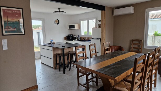 A modern kitchen with a central island, wooden dining table, and chairs. - House 5 mn walk from the center of aiguillon (L'Aiguillon-la-Presqu'île)