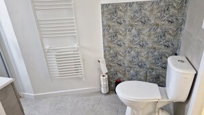 A bathroom with a toilet, a towel rack, and a patterned wall. - House 5 mn walk from the center of aiguillon (L'Aiguillon-la-Presqu'île)