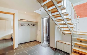 Et moderne interiør med en spiraltrappe, knagerække og en radiator.