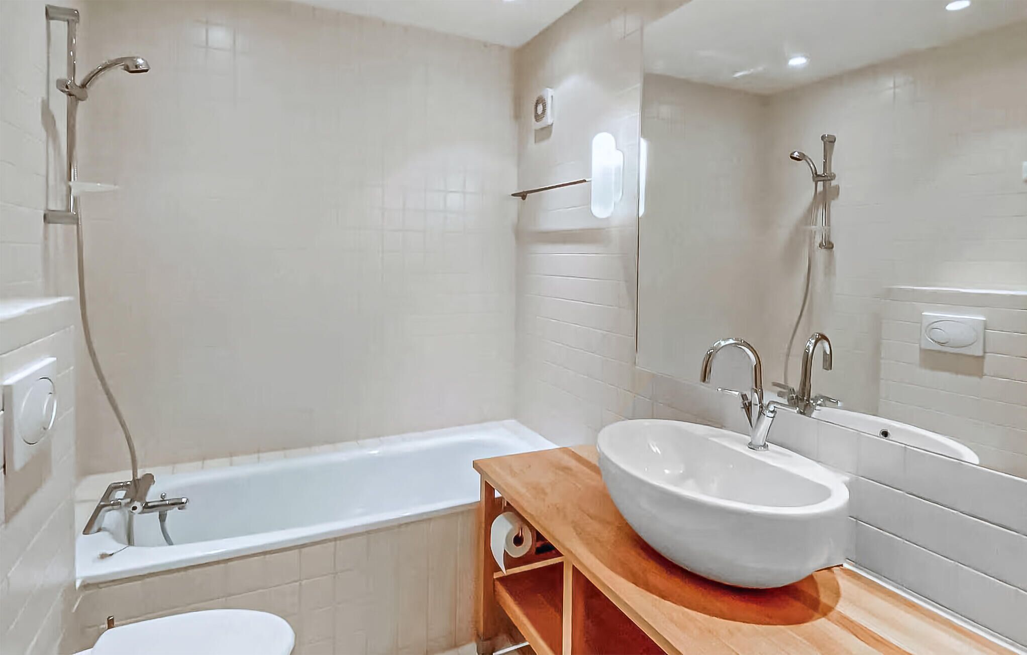 A modern bathroom with a bathtub, a sink, and a toilet.