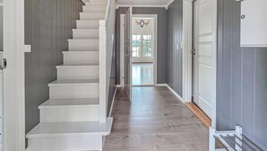 A staircase leading to a door with a glass panel, a wooden floor, and a metal handrail. - Amazing home in ørje with WiFi (Ørje)