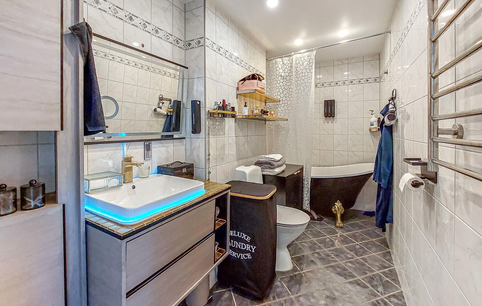 Uma casa de banho moderna com lavatório, espelho e sanita.
