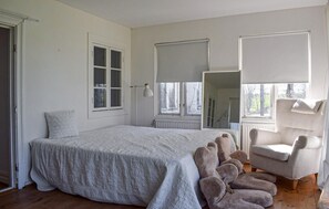 A bedroom with a large bed, a chair, a window, and a radiator. - 4 bedroom nice home in Trelleborg (Trelleborg)